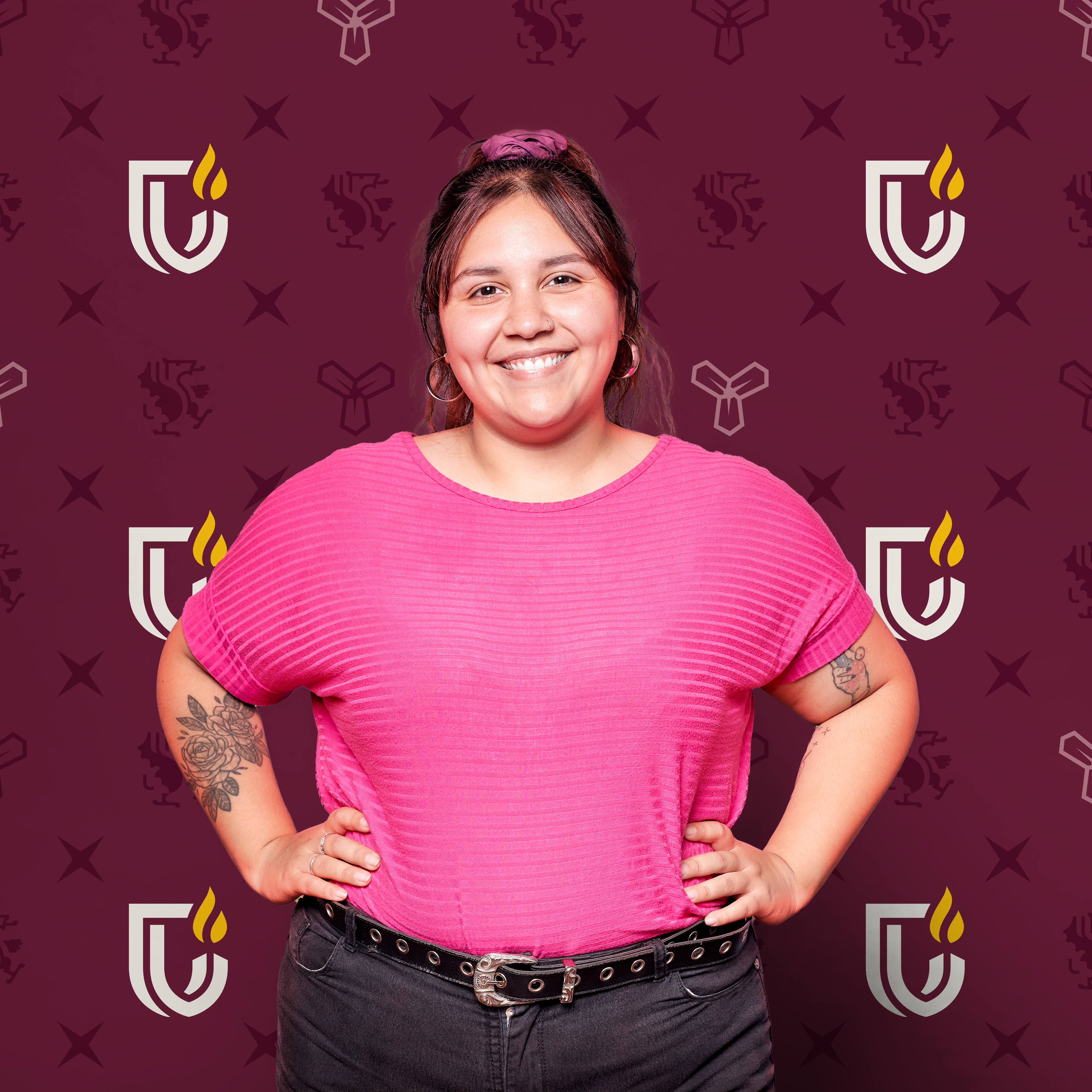 Woman in front of a backdrop that features the Cambrian College logo in a pattern on a burgundy background